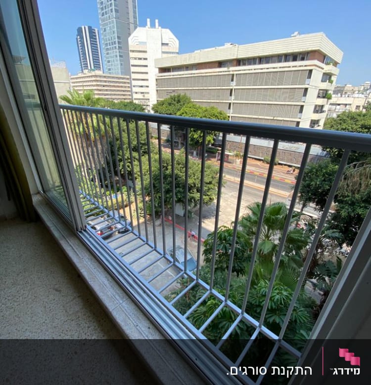 מעקה מתכת במרפסת עם נוף עירוני